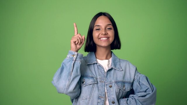 woman pointing a great idea and looking up on green screen chroma key background