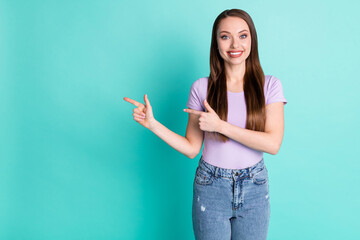 Fototapeta na wymiar Photo portrait of beautiful girl smiling pointing at blank space with both hands isolated on vibrant teal color background