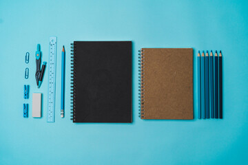 book, pencil, ruler on a blue background.