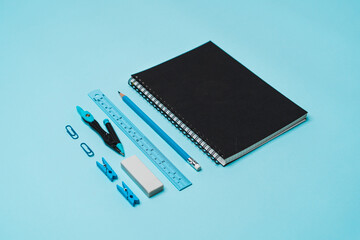 book, pencil, ruler on a blue background.