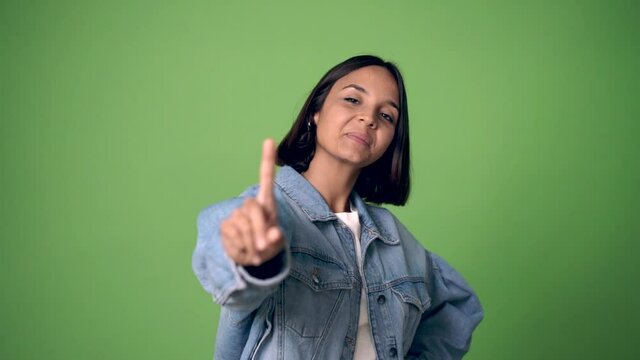 woman showing and lifting a finger in sign of the best on green screen chroma key background