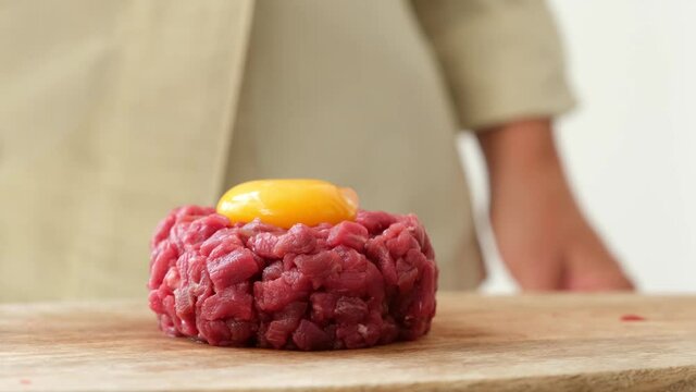 Crop female cook preparing Steak tartare