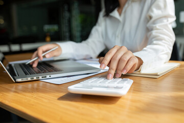 Business accounting Finances Saving Economy concept.Business using calculator and laptop and pen.