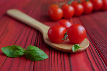 Cherry tomatoes in a spoon on a wooden background