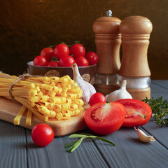 Tagliatelle pasta is tied with a cord on a wooden board around vegetables, spices and herbs