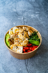 Healthy Protein Fitness Food Chicken, Egg, Spinach, Avocado and Cucumber with Fitness Equipment Dumbbells for Athlete in Plastic Bowl.