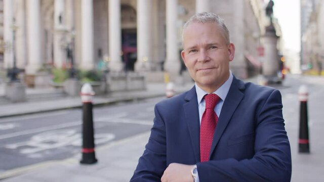 Portrait of successful mature business man folding his arms and smiling to camera 