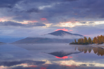 Autumn foggy morning on a mountain lake