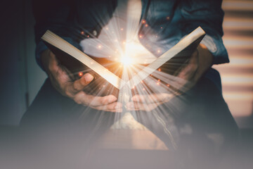 The light coming from the book in the hand of man concept wisdom religion reading imagination.