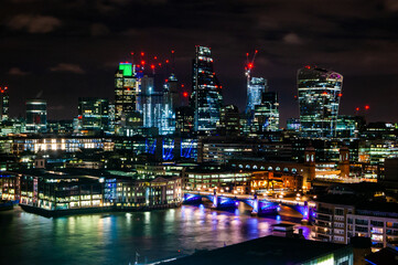 Night cityscape skyline of London downtown with Thames river, famous bridges and modern business center skyscrapers on the background