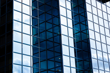 Fototapeta premium Contemporary blue glass and metal facades of skyscrapers full of offices. Cornered exterior design playing with light and shadow.