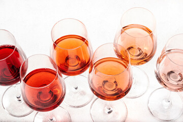 Rose wine glasses set on wine tasting. Degustation different varieties, colors and shades of pink wine concept. White background, top view