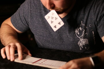 card magician practicing sleight of hand magic card in mouth