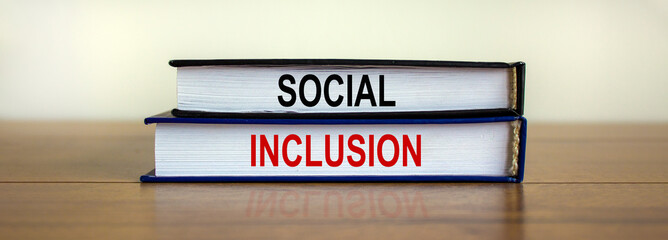 Books with text 'social inclusion' on beautiful wooden table. White background. Business concept. Copy space.