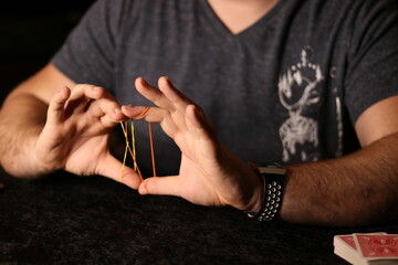 close up of a magician practicing a rubberband trick
