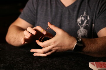 close up of a magician practicing a rubberband trick