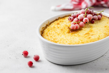 Cheesy rice bake decorated with frozen berries. Space for text.