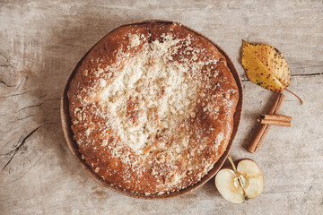 Homemade apple pie and cinnamon on vintage wooden background texture. Top view. Copy, empty space for text