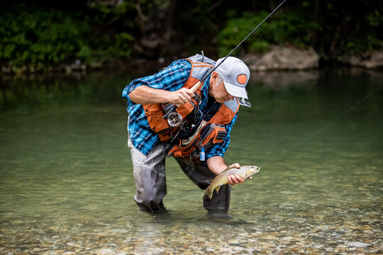 A fly fisherman fishing a trouts in mountain river