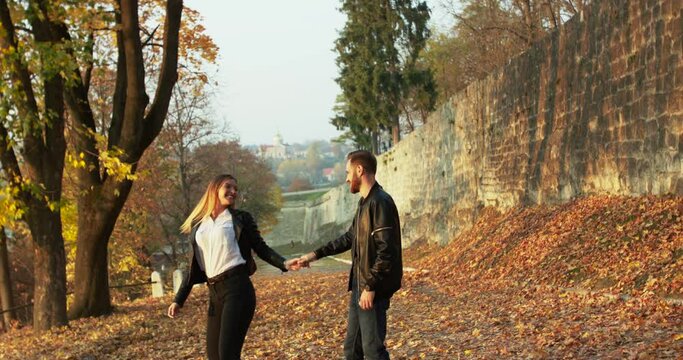 Romantic couple having lovestory on walk, they dancing and kissing in autumn