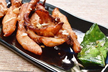 deep fried salty chicken with garlic and lemon leaf on plate