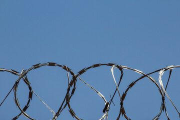 Foto de detalhe de concertina com céu azul ao fundo.
