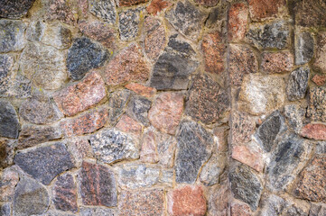 Wall of granite pieces of stones fastened with cement, horizontal orientation