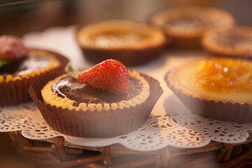 Close up of delicious strawberry and chocolate tartelette on sale at confectionery store