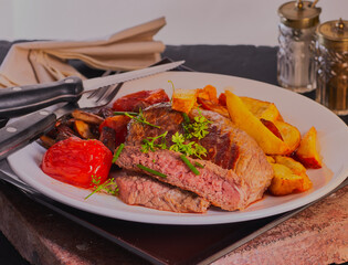 Beef steak with potato wedges,mushrooms and tomatoes.