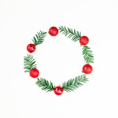 Christmas frame of evergreen branches and red balls on white background. Flat lay