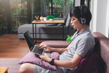 Businessman meeting online via video call on laptop in home office. Man wear headphone video...