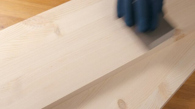 Untitled Project 3a man sanding a pine board with sandpaper
