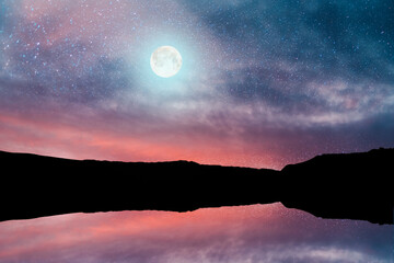 Fototapeta premium Beautiful full moon over the mountains and reflection in the water. Starry sky.