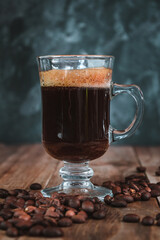 Black coffee in glass cup on wooden table