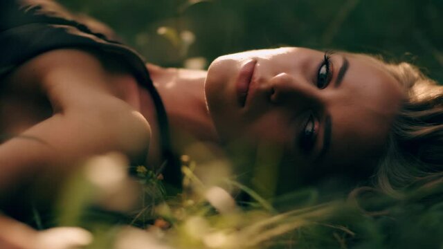 Beautiful woman with clean skin. Natural make-up. Young attractive cute model is touching and showing her perfect skin face at green nature background
