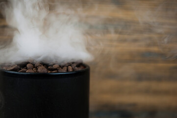 Fototapeta na wymiar coffee beans roasted with smoke and wood background