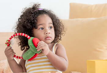 African little black girl playing ear muff in color of christmas in living room