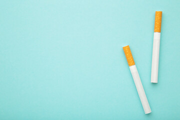 Two cigarettes on blue background. Top view.