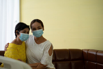 Senior Asian woman  in hospital with daughter taking care with protective face mask.  Health care and medicine concept.