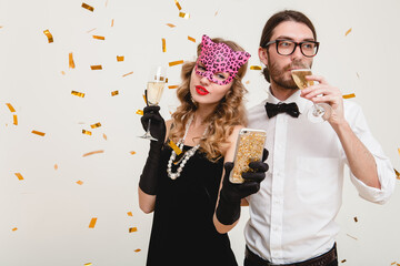 young stylish couple in love on white background holding glasses and drinking champagne, making...