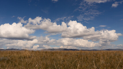 Steppe meadow in Khakassia. Landscape with a grass, hills and the sky.