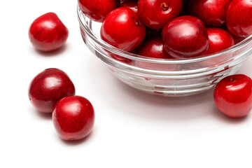 fresh black cherries in a glass plate on a white background