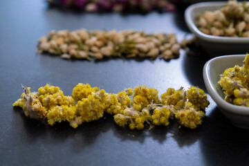 Large variety of multi colored dried tea leaves and flowers shot on white table