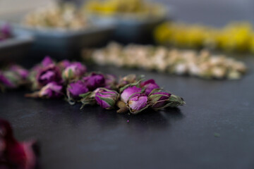 Large variety of multi colored dried tea leaves and flowers shot on white table