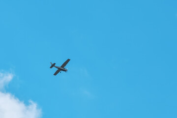 Small light aircraft flying in the blue sky