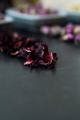 Large variety of multi colored dried tea leaves and flowers shot on white table