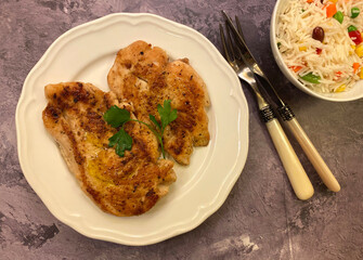 Classic dish. In pan seared natural chicken cutlets, also known as chicken breasts with vegetable rice.