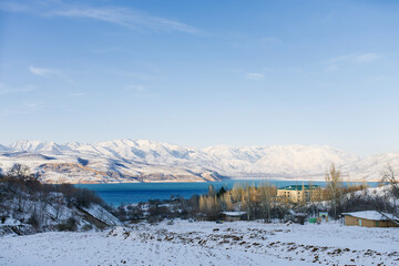 Fototapeta na wymiar Charvak mountain lake in Uzbekistan on a snowy frosty day, surrounded by the Tien Shan mountains