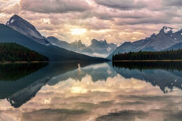 A sunrise on cloudy day across Maligne Lake, Jasper, AB, Canada