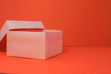 on the left, an empty pink box stands open on a red background.